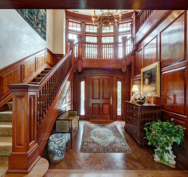 Entering through the lustrous, custom made front door of solid mahogany, one passes underneath the wide landing of a sweeping grand staircase and sees almost straight through to the elegant French doors that open onto the house's sweeping back view.