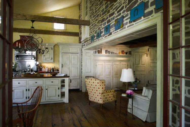 Removing a drooping overhang was the first step needed for the kitchen addition, revealing this marvelous stone wall. The quaint Dutch door opened into a former laundry room; now, with the bottom bolted shut, it serves as a reminder of the home’s history. Leaving the top half of the door open is a charming way to entice family members down to the kitchen for breakfast.