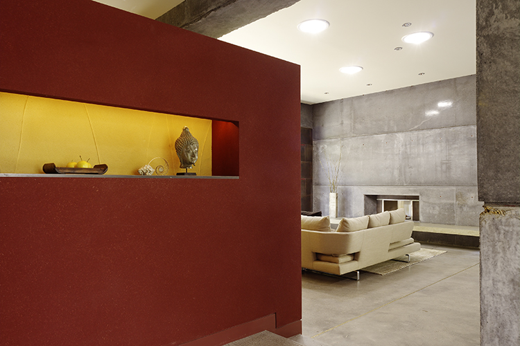 The welcoming foyer uses color and lighting to complement the main living room and its massive concrete fireplace.