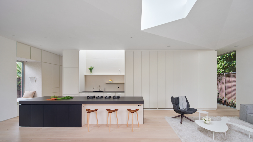 white kitchen with black island in minimalist LA home