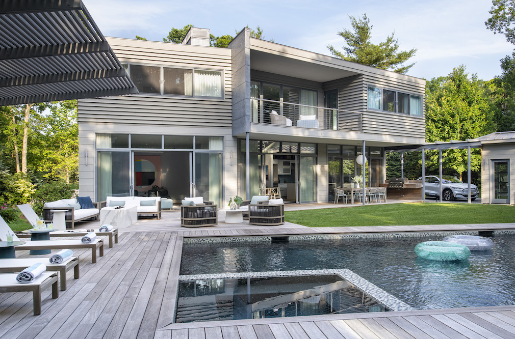 backyard pool behind a gray east hampton beach house